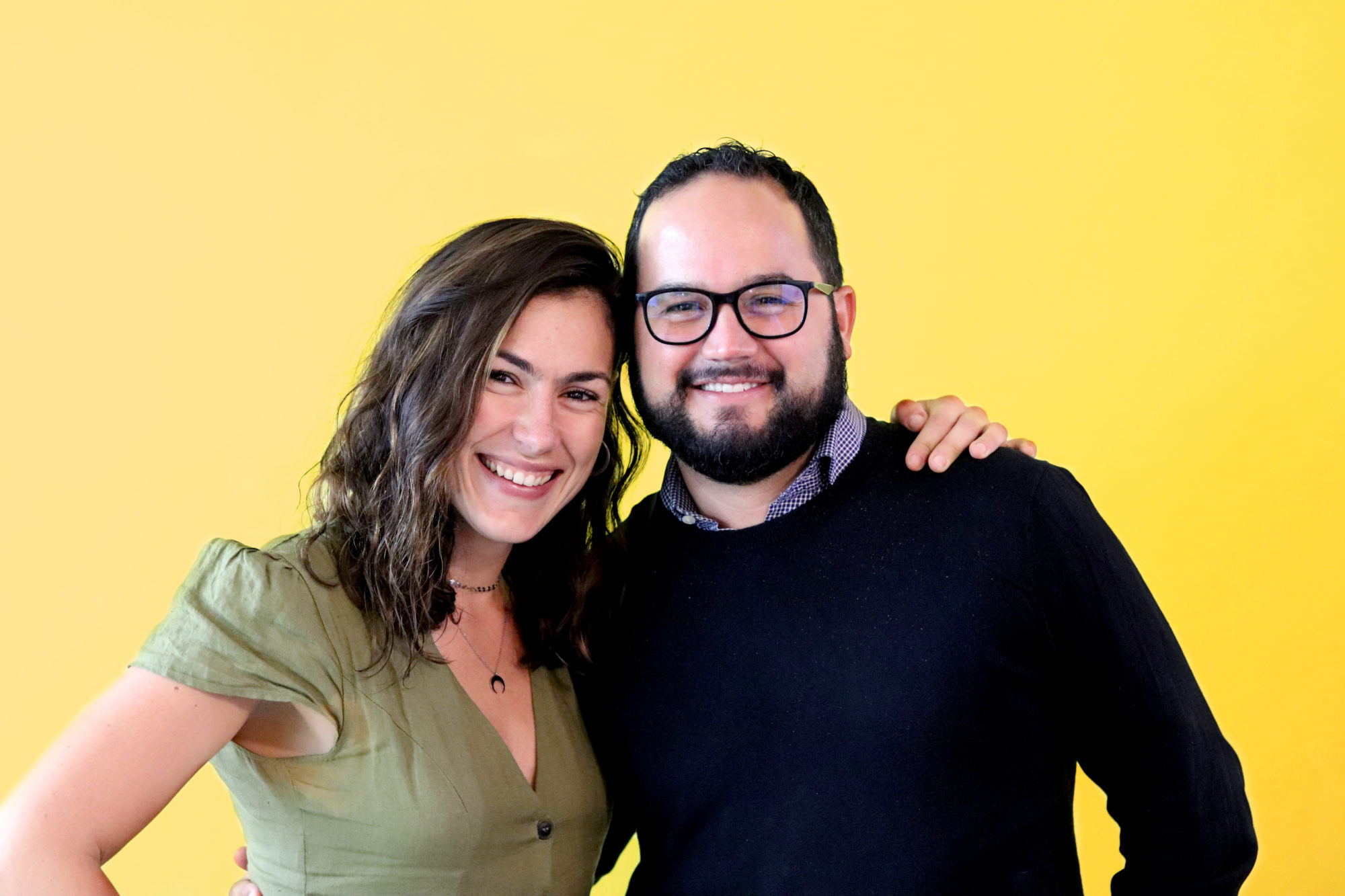 Friendly PathFactory employees Andrea and Juan smiling with arms on each other's shoulders